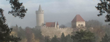 Pohled na hrad Kokořín, který vyčnívá nad okolními lesy.